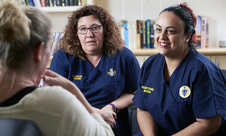 Two female mental health nurses in conversation with another woman