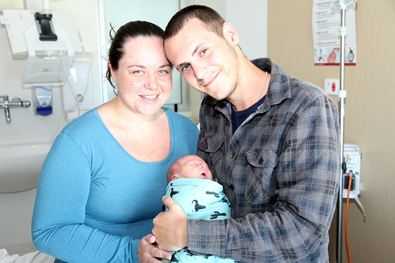 Mother and father holding newborn baby boy