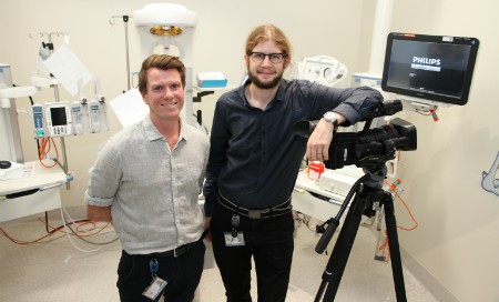 Consultant Neonatologist Rory Trawber and Clinical Videographer Jason Janetzky standing next to a video camera and monitor