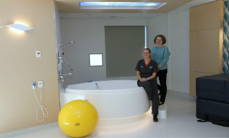 Two women standing next to birthing bath