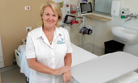 Lynda Deacon standing by a hospital bed