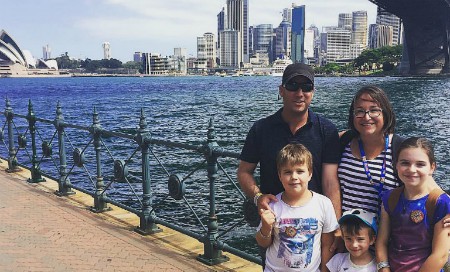 Family of five stands in front of Sydney city landscape