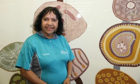 FSH volunteer Marie Rawson standing in front of some Aboriginal art