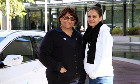 Two Aboriginal women standing beside a Fiona Stanley Hospital car